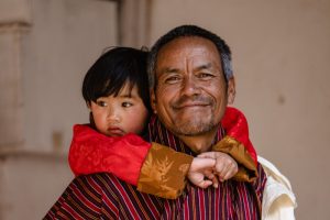 Elderly man and young worshiper at Tshechu festival