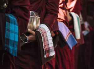 Monks in vibrant robes holding alms bowls